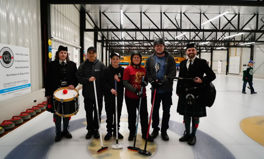 Curling team members with Fergus Pipe Band members at 2024 Curl For A Cause.
